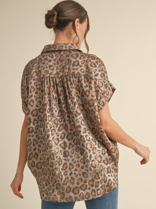 Woman wearing a leopard print shirt against a beige background