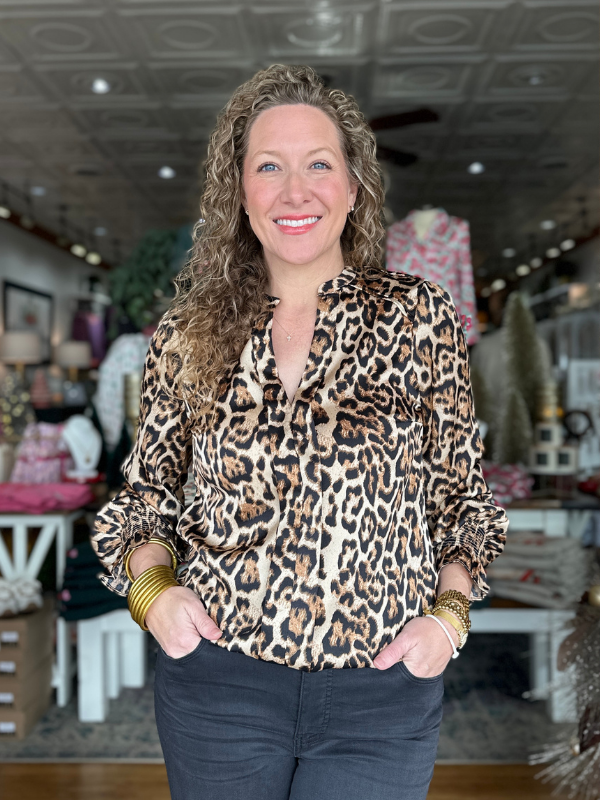 Woman wearing a leopard print blouse in a store setting