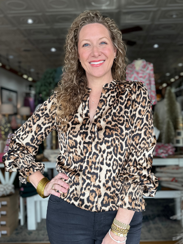 Woman wearing a leopard print blouse in a store setting