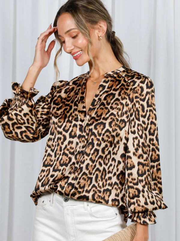 Woman wearing a leopard print blouse against a white background
