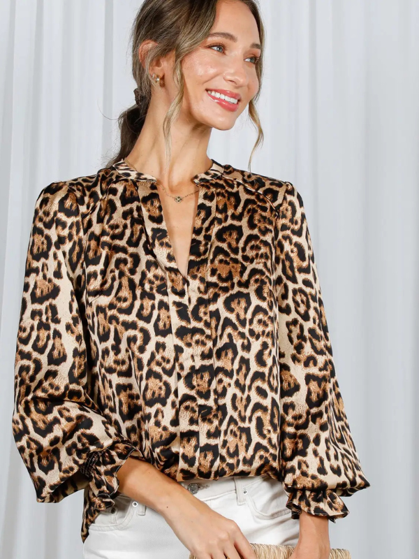 Woman wearing a leopard print blouse against a white background