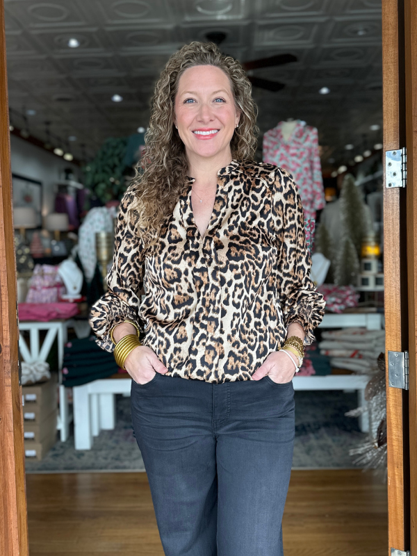 Woman wearing a leopard print blouse in a store setting