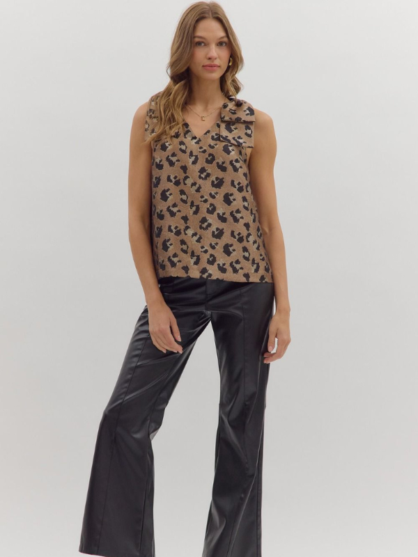 Woman wearing a leopard print top and black pants on a white background