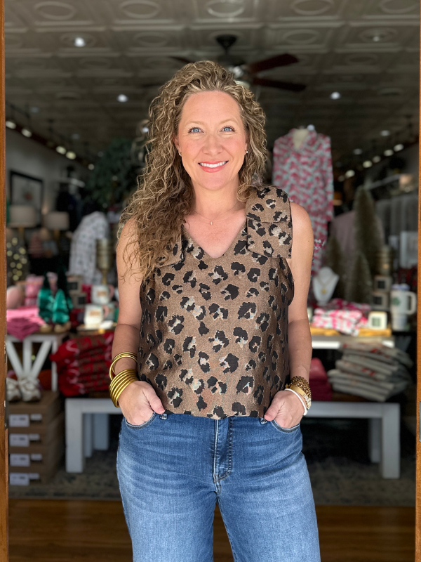 Woman wearing a leopard print top and blue jeans in a store setting