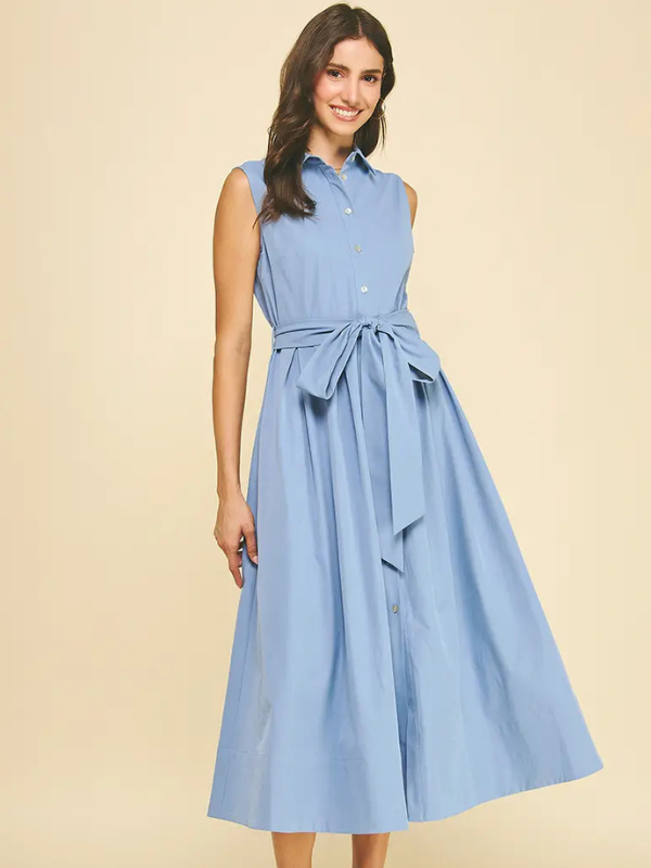 Woman wearing a light blue dress with a belt on a beige background