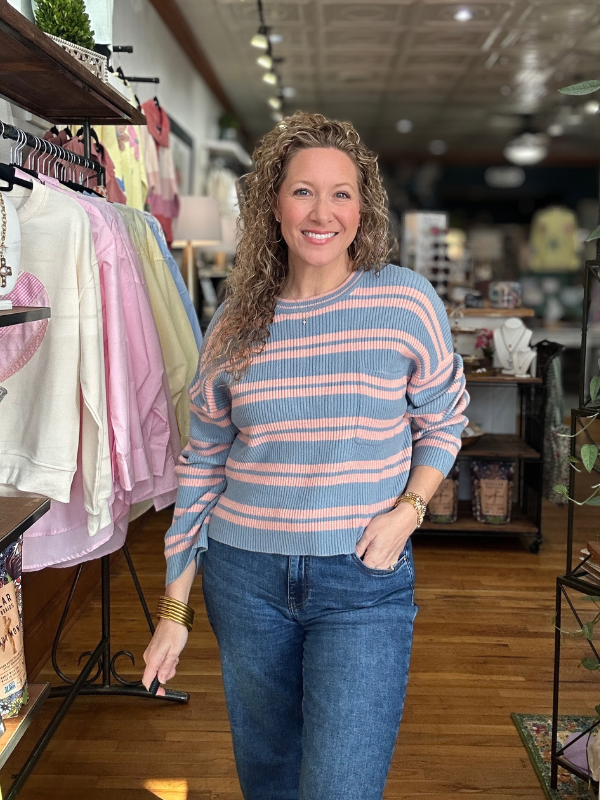 Woman wearing a striped sweater and jeans in a store setting
