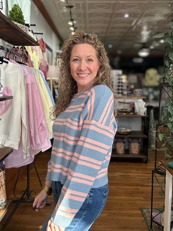 Woman wearing a striped sweater in a store setting