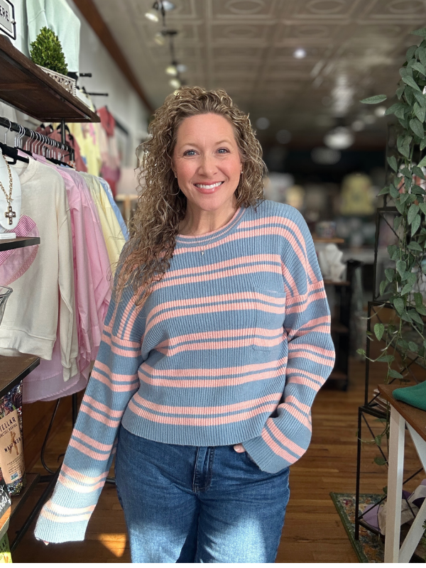 Woman wearing a striped sweater in a store setting
