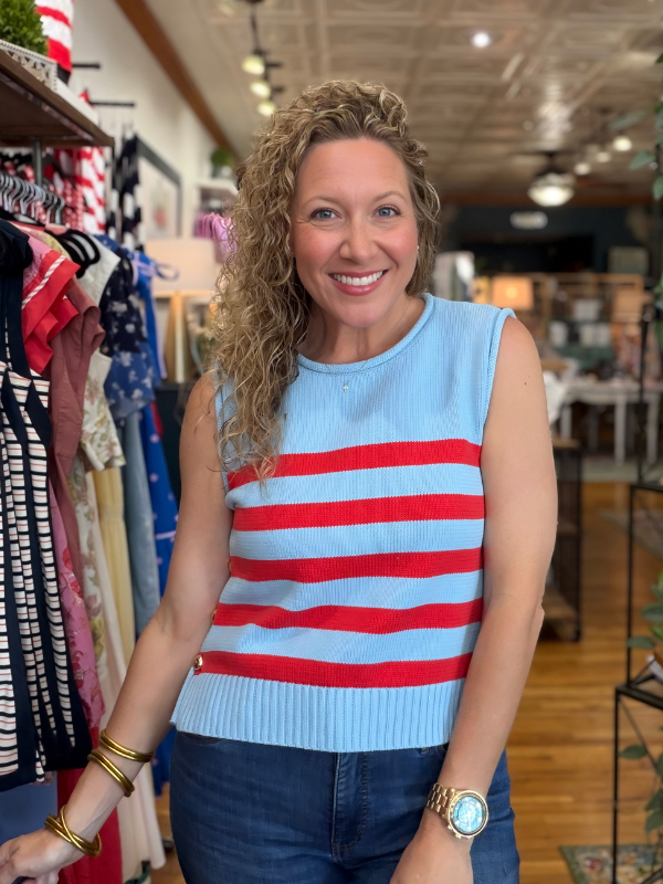 Woman wearing a blue and red striped sleeveless sweater in a store setting