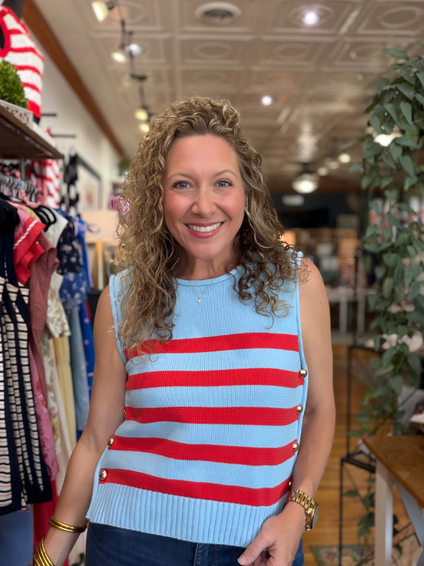 Woman wearing a red and blue striped sweater vest in a store setting