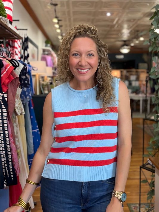 Woman wearing a blue and red striped sleeveless sweater in a store setting