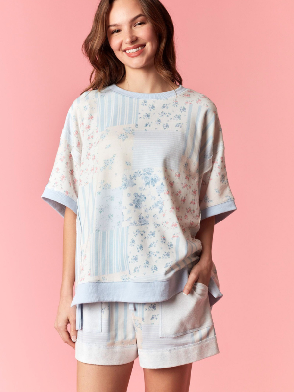 Woman wearing a floral pajama set against a pink background