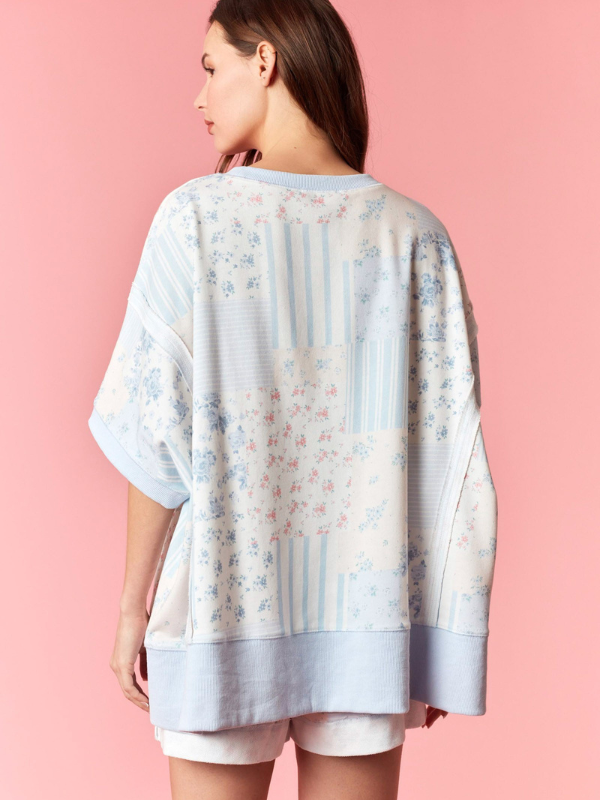 Woman wearing a floral kimono-style garment against a pink background