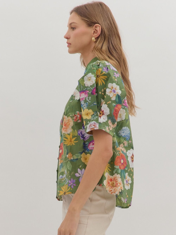 Woman wearing a green floral blouse against a white background