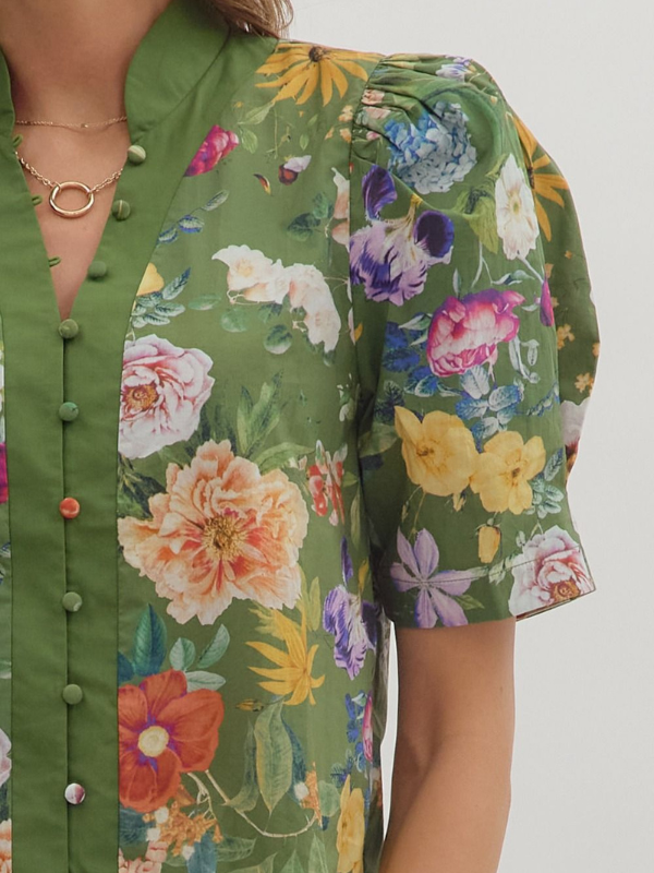 Green floral shirt with colorful flowers on a plain background