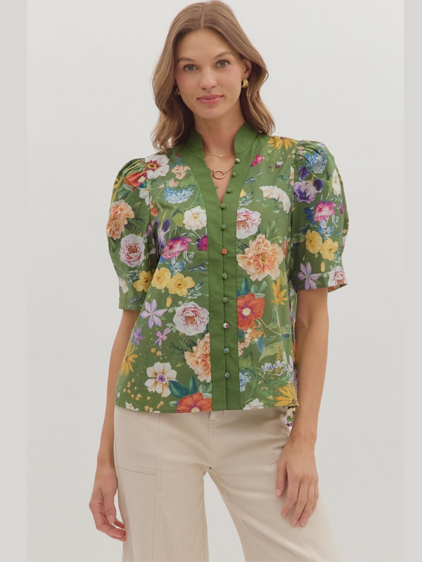 Woman wearing a green floral blouse against a white background