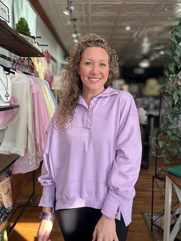 Woman wearing a purple sweatshirt in a store setting