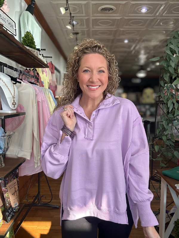 Woman wearing a light purple sweatshirt in a store setting