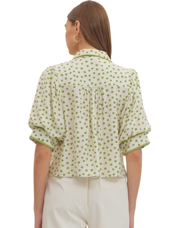 Woman wearing a green polka dot blouse on a white background