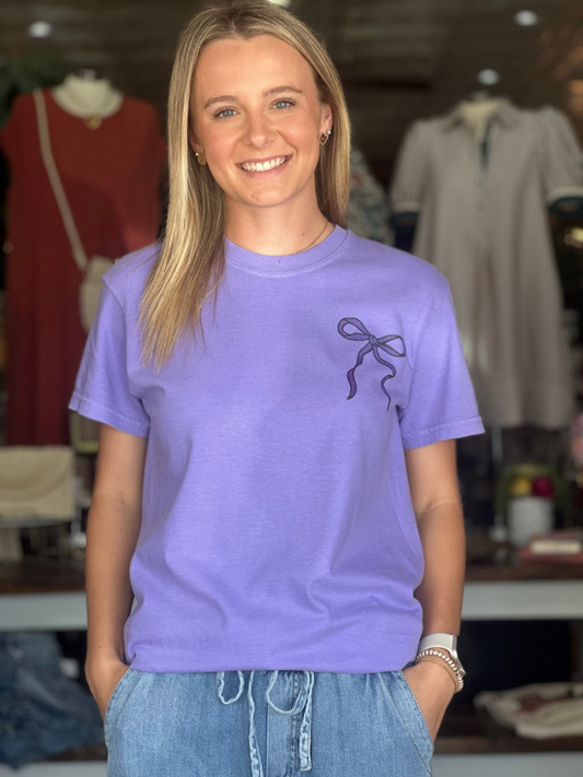 Woman wearing a purple t-shirt with a design in a clothing store