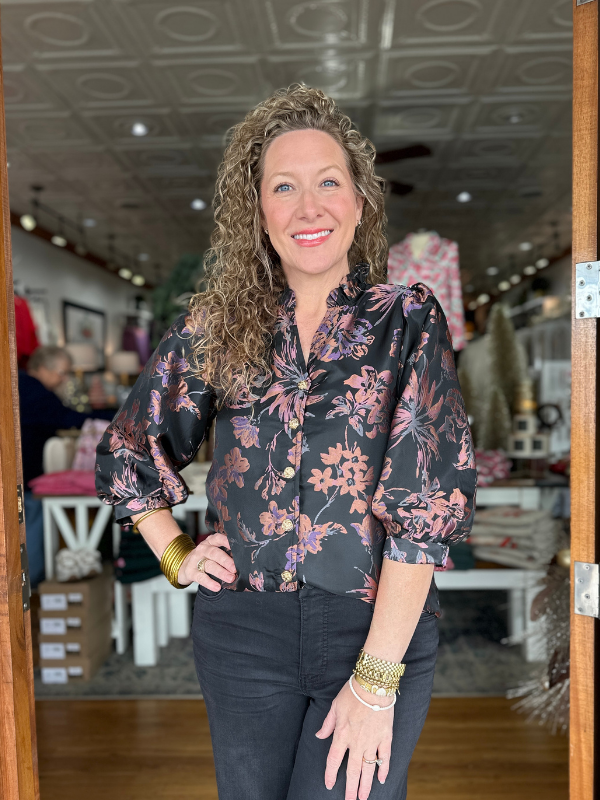 Woman wearing a floral blouse in a store setting