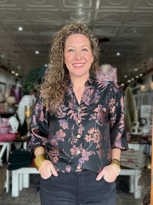 Woman wearing a floral blouse in a store setting