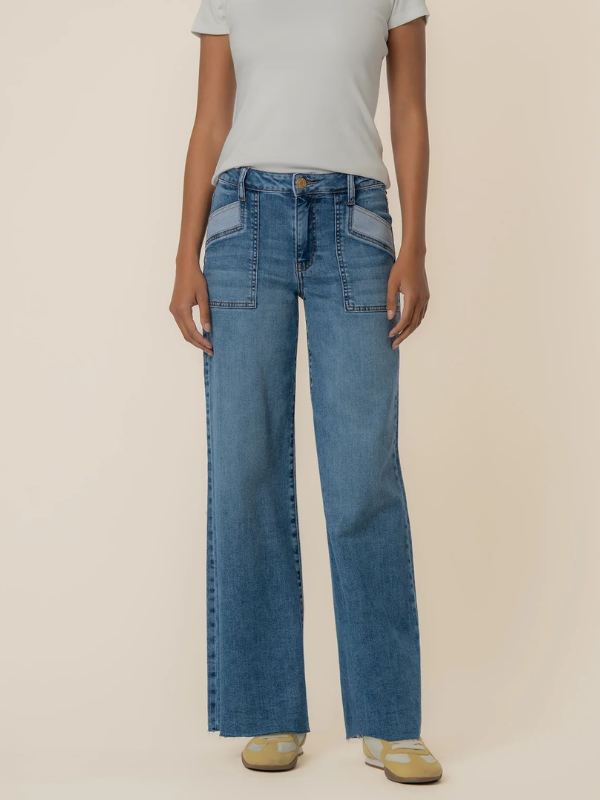 Person wearing blue jeans and a light gray shirt on a beige background