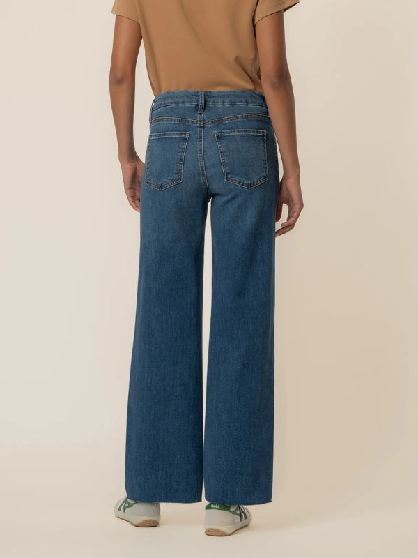 Person wearing blue jeans on a beige background