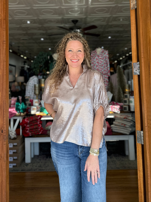 Woman standing in a store with clothing and decor in the background