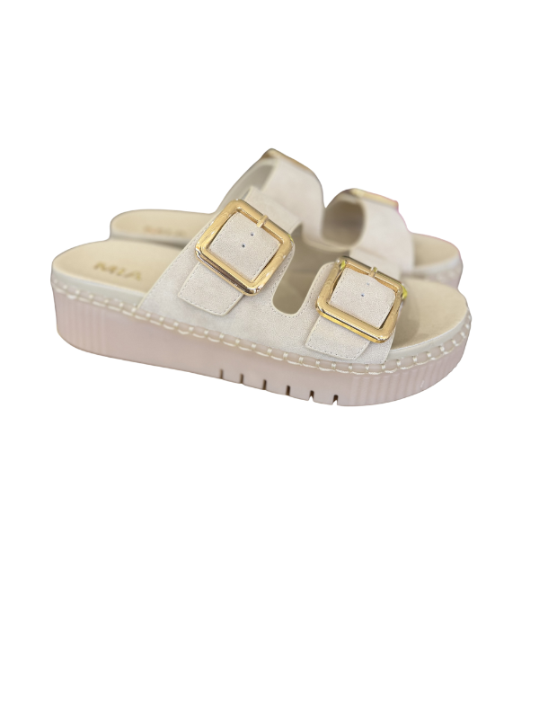 White sandal with gold buckles on a white background