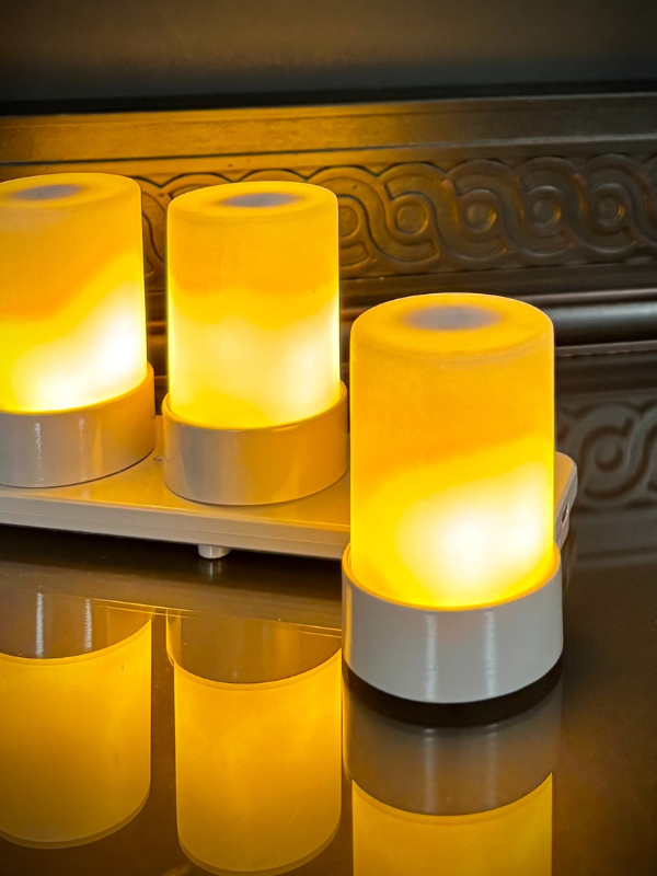 Set of glowing cylindrical lamps on a reflective surface with a decorative background