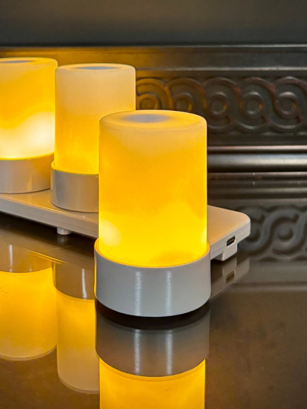 Yellow cylindrical lamp with metallic base on a reflective surface