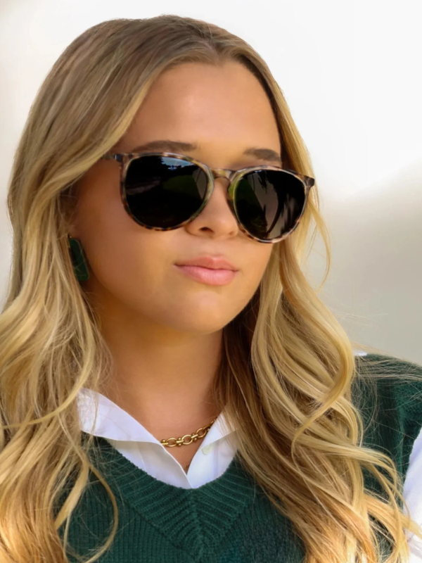 woman wearing sunglasses with brown tortoise frames and black lenses 