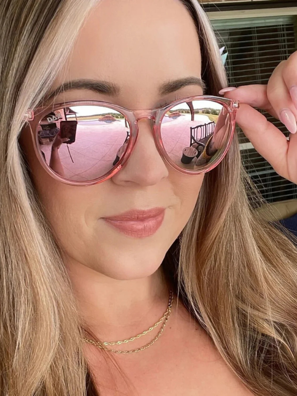 Person holding pink reflective sunglasses