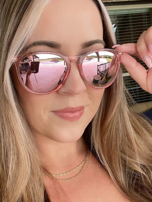 Person holding pink reflective sunglasses