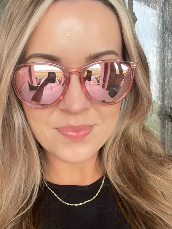 Person wearing pink reflective sunglasses with a blurred background