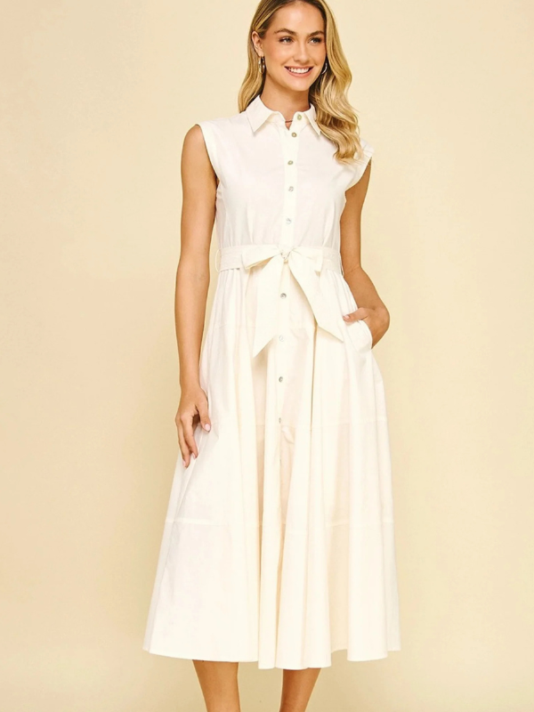 Woman wearing a white sleeveless dress against a beige background