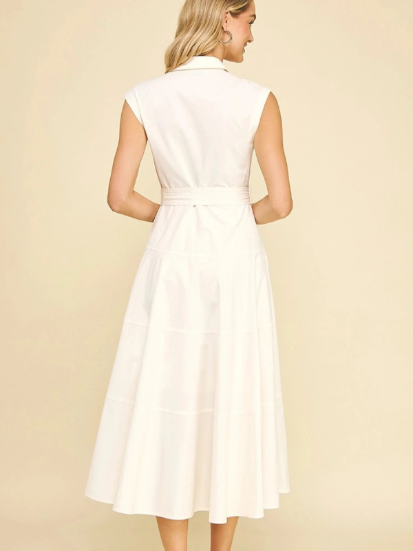 Woman wearing a white dress against a beige background