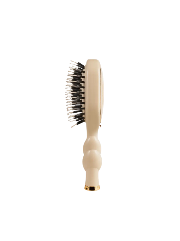 Beige hairbrush with black bristles on a white background