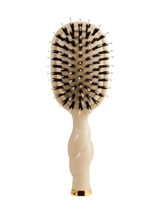 Beige hairbrush with black bristles on a white background