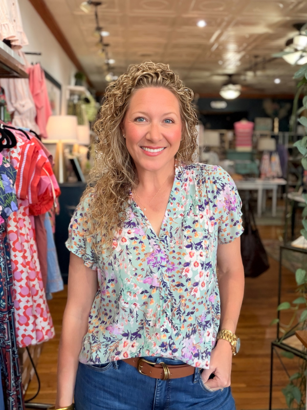 Woman wearing a floral blouse in a clothing store