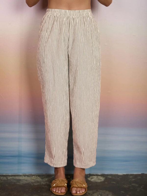 Person wearing beige striped pants with a blurred background