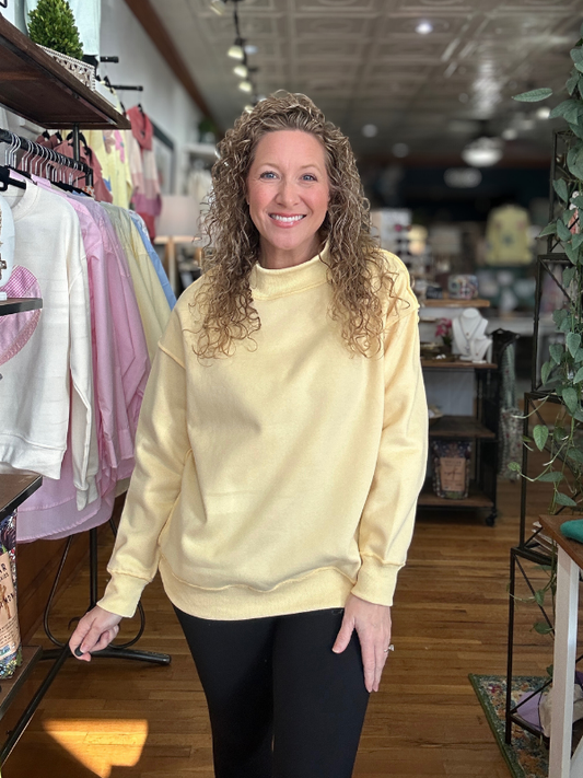 Woman wearing a yellow sweatshirt in a store setting