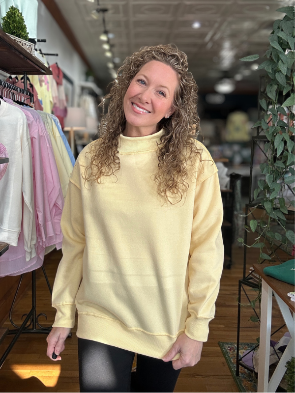 Woman wearing a yellow sweatshirt in a store setting