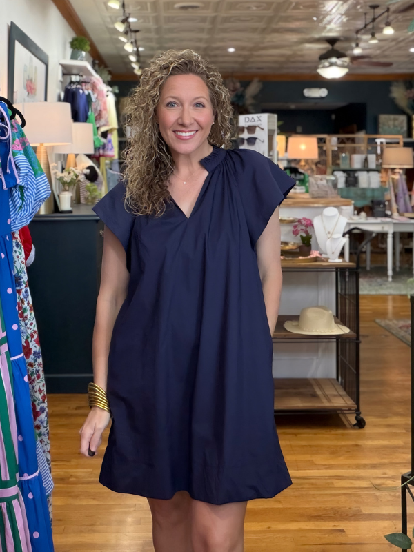 Woman wearing a navy blue dress in a store setting
