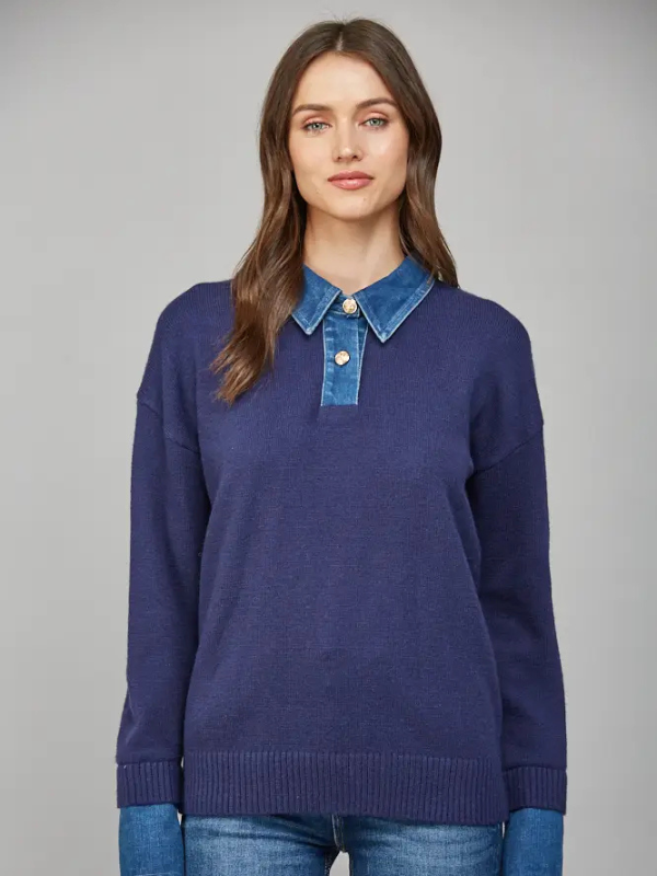 Woman wearing a blue sweater with a denim collar against a gray background