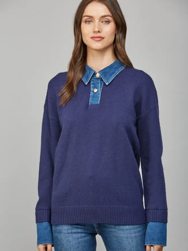 Woman wearing a blue sweater with a denim collar against a gray background