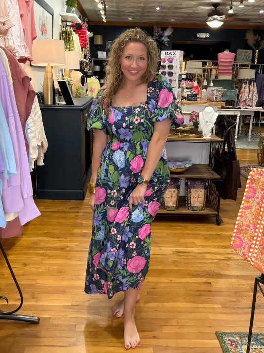 Woman wearing a floral dress in a store setting