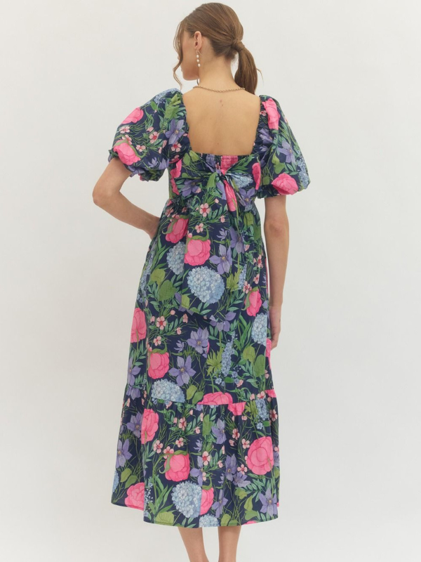 Woman wearing a floral dress with puff sleeves on a white background