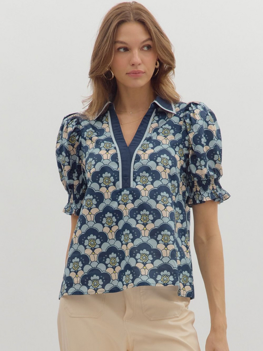 Woman wearing a floral patterned blouse with puff sleeves on a white background